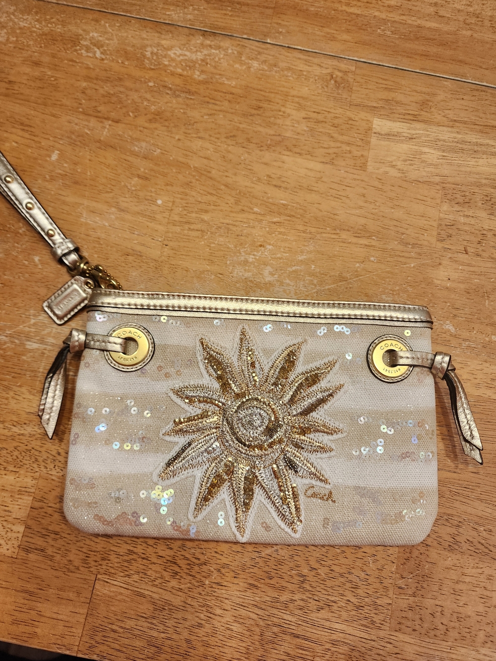 Coach Audrey Sun wristlet featuring a standout beaded sequined gold sunflower